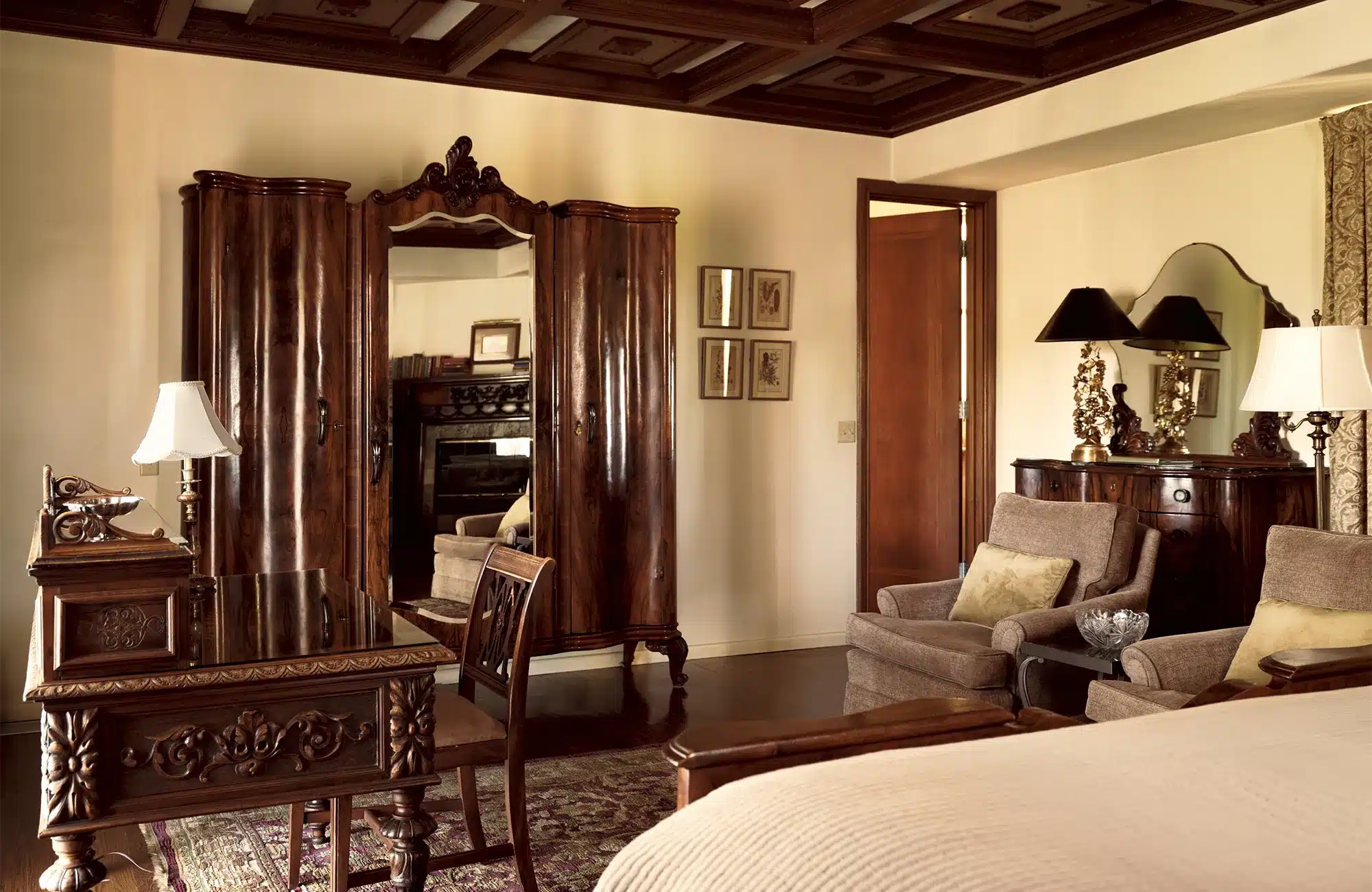 Library room with bed, armoire, desk, two chairs, and drresser