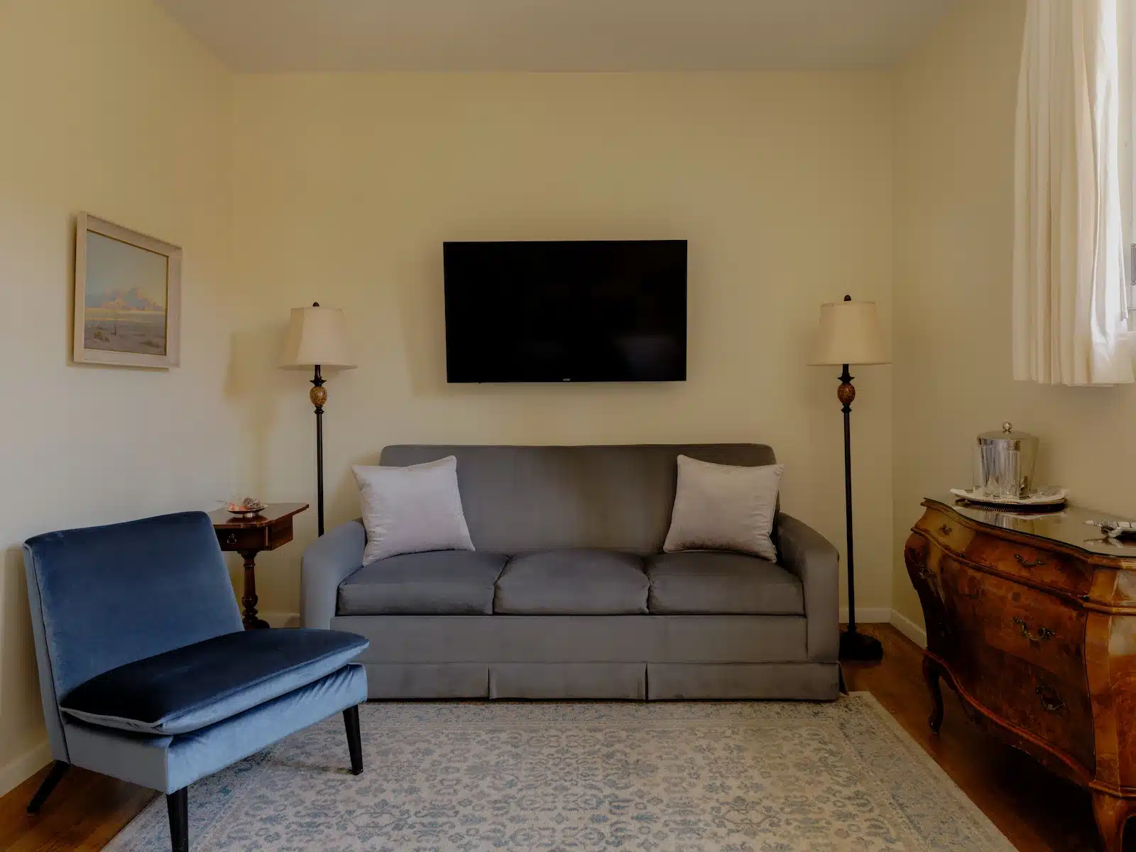 Terrace sitting area with couch, chair and tv above couch