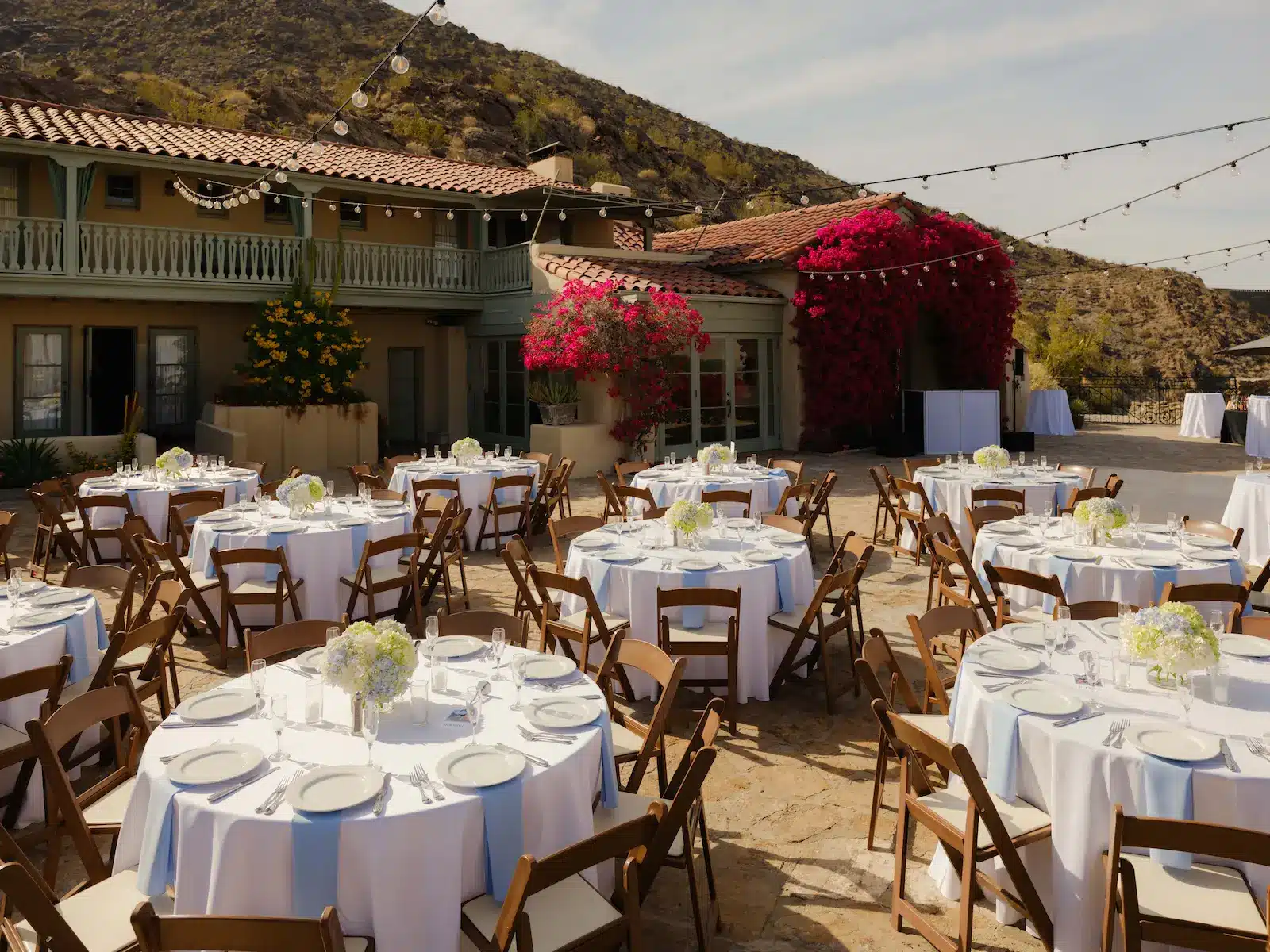 Outdoor wedding reception setup on patio with 10 round tables