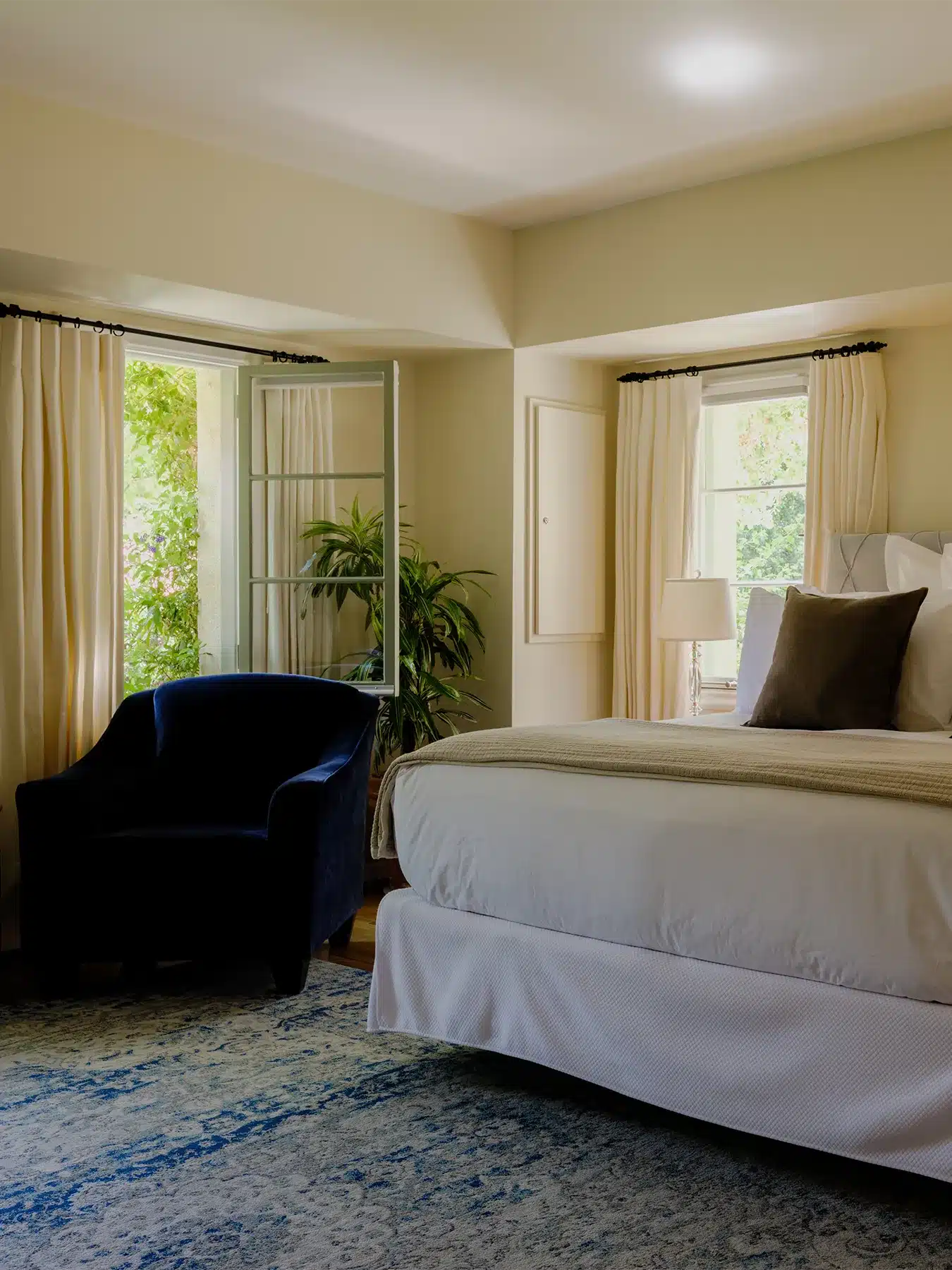 Pal Verde room with bed, chair, and window open next to garden