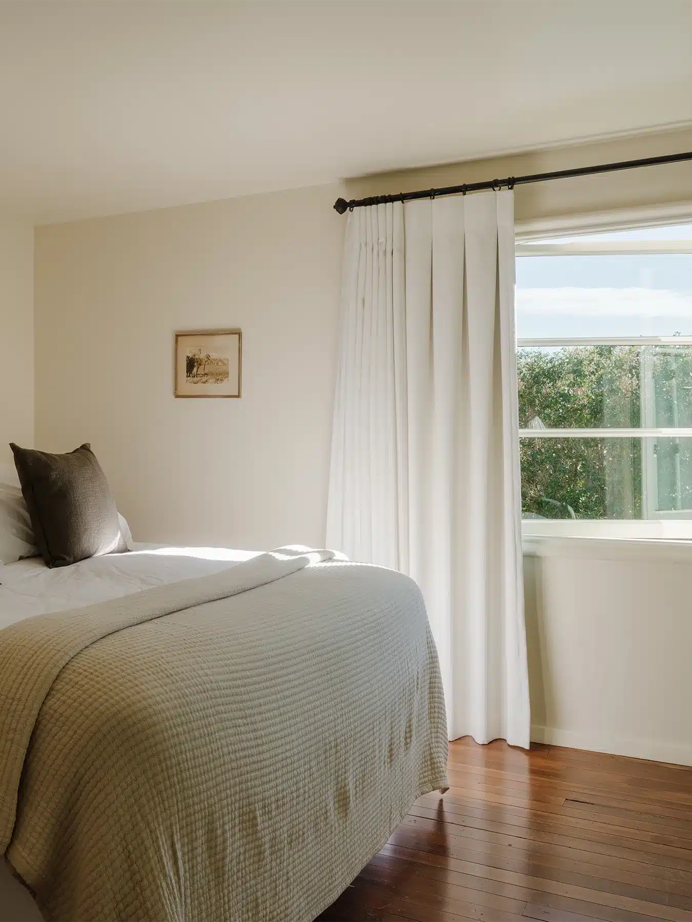 Tahquiz room with bed and light filled open window