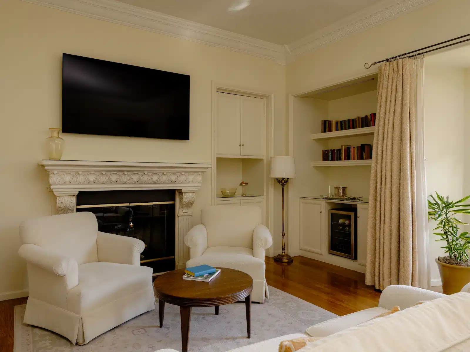 Mario Davies sitting area with fireplace, tv, two chairs and couch